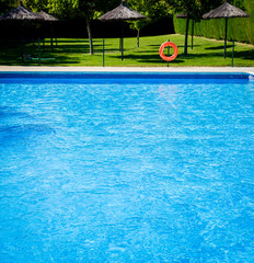 Closeup view of the swimming pool edge with blue water copy space during a sunny summer day
