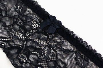 Lace black belt for stockings or suspenders on a peach background