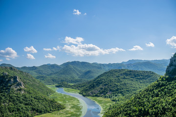 Fototapeta premium The picturesque meandering river flows among green mountains.