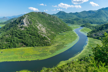 The picturesque meandering river flows among green mountains.