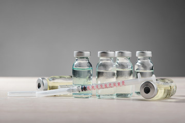 Vials and syringe on gray
