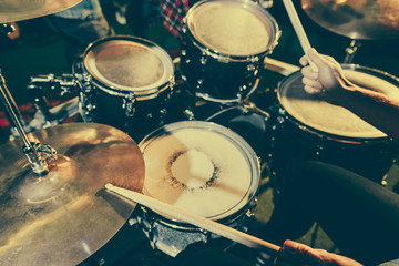 cropped view of drummer holding drum sticks while playing drums