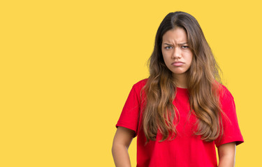 Young beautiful brunette woman wearing red t-shirt over isolated background skeptic and nervous, frowning upset because of problem. Negative person.