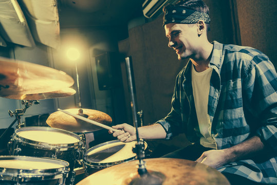 Selective Focus Of Happy Drummer Holding Drum Sticks While Playing Drums