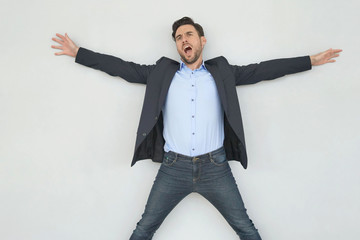 Business man jumping with joy on grey background