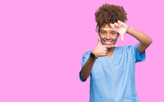 Young african american doctor woman over isolated background smiling making frame with hands and fingers with happy face. Creativity and photography concept.