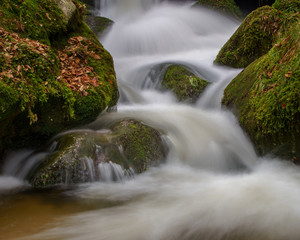 Fototapeta premium Wasserfall mit Steinen voller Moos