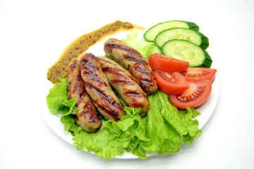 fried sausages and salad on a white plate