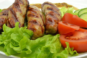 fried sausages and salad on a white plate