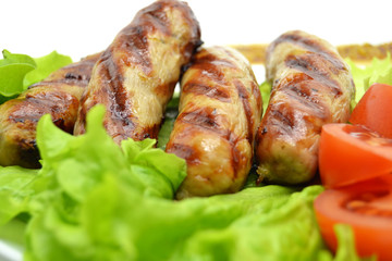 fried sausages and salad on a white plate