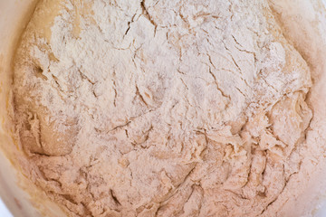 Dough for pizza. Rolling pin and dough on wooden background