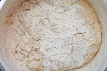 Dough for pizza. Rolling pin and dough on wooden background