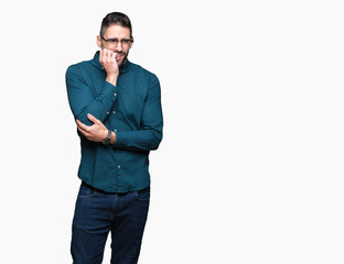 Young handsome business man wearing glasses over isolated background looking stressed and nervous with hands on mouth biting nails. Anxiety problem.