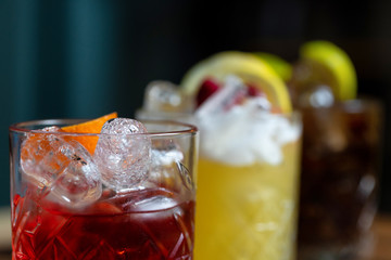Glasses of cocktails on bar background