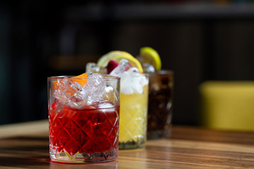 Glasses of cocktails on bar background