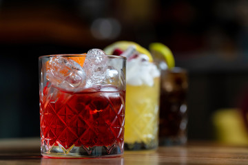 Glasses of cocktails on bar background