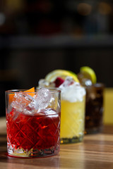 Glasses of cocktails on bar background