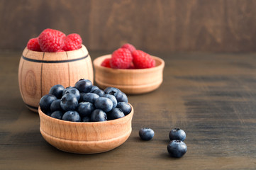 wild berries, raspberries and blueberries on a brown background.