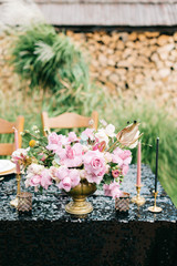 Elegant black and pink table setting for wedding reception with bouquets