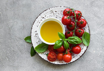 Plate with cherry tomatoes, olive oil and basil