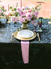 Elegant black and pink table setting for wedding reception with bouquets