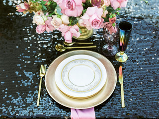 Elegant black and pink table setting for wedding reception with bouquets