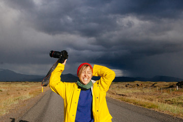 Happy smiling woman with camera, traveling Iceland, enjoying