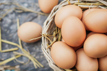 chicken eggs in basket on wooden table closeup 