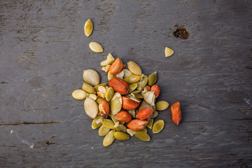 Raw peeled peanuts and pumpkin seeds on the wooden table
