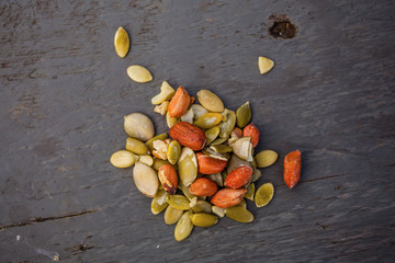 Raw peeled peanuts and pumpkin seeds on the wooden table
