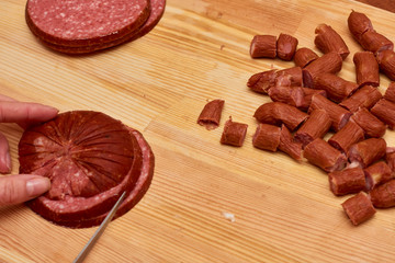A variety of processed cold meat products, on a wooden cutting board