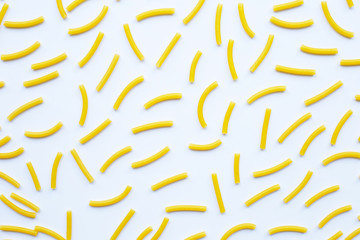 Uncooked macaroni on a white background.