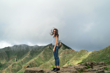 Pretty tourist brunette girl relaxing near mountains.