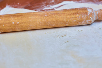 Dough for pizza on the wooden table, close-up. Dough for pizza.