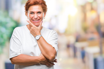 Atrractive senior caucasian redhead woman over isolated background looking confident at the camera with smile with crossed arms and hand raised on chin. Thinking positive.