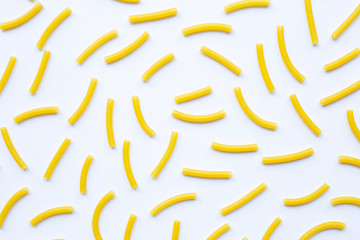 Uncooked macaroni on a white background.
