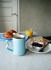 breakfast. side view. light background. scrambled eggs, orange juice, toast, jam, croissants, coffee, milk, morning, close up