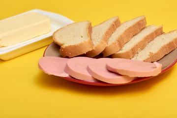 Sliced boiled sausage with bread, butter
