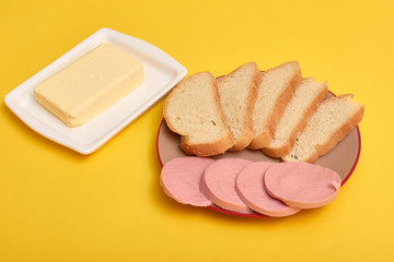 Sliced boiled sausage with bread, butter