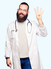 Young blond doctor man with beard wearing medical coat showing and pointing up with fingers number four while smiling confident and happy.