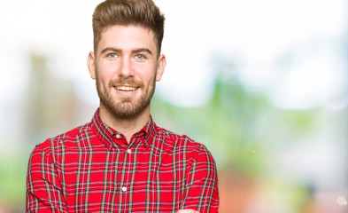 Fototapeta premium Young handsome man happy face smiling with crossed arms looking at the camera. Positive person.
