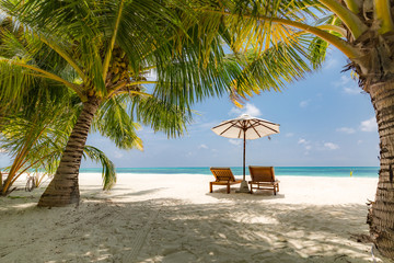Beautiful beach. Chairs on the sandy beach near the sea. Summer holiday and vacation concept. Tropical beach landscape. Exotic vacation and summer holiday concept design © icemanphotos