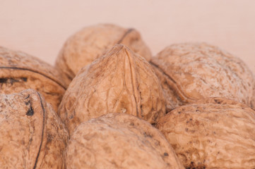 Walnuts on wooden background, board, close-up macro, side view, copy space for text.