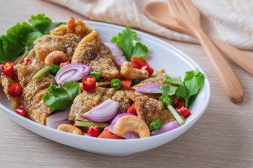 Spicy crispy gourami fish salad on plate, Thai food.