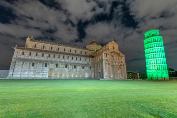 Pisa Leaning Tower and Cathedral for St Patrick's day celebrations illuminated by green lights.