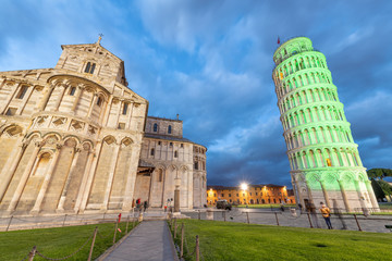 Pisa Tower and Cathedral in Miracles Square for St Patrick's Day illuminated by green lights, Tuscany - Italy