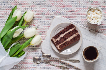 Bouquet of white tulips, coffee and chocolate cake