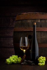 white wine bottle and wine glass on wodden barrel