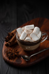 coffee with milk and marshmallow with cinnamon and anise on wooden background