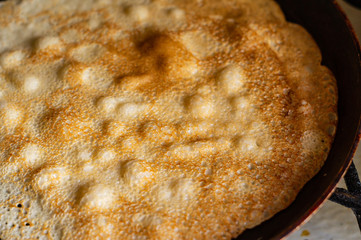 Thin pancakes in a pan on the stove